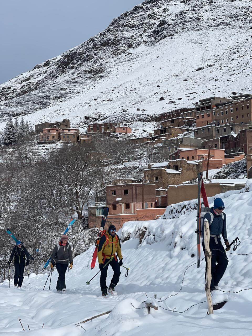 Ski touring group returning through a mountain village in the Moroccan High Atlas