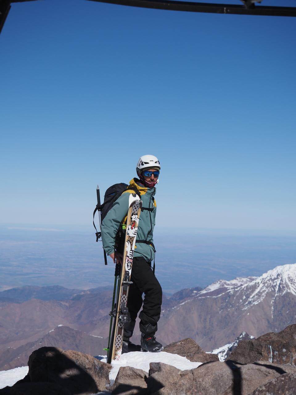 Skier standing with skis near the summit of Mount Toubkal