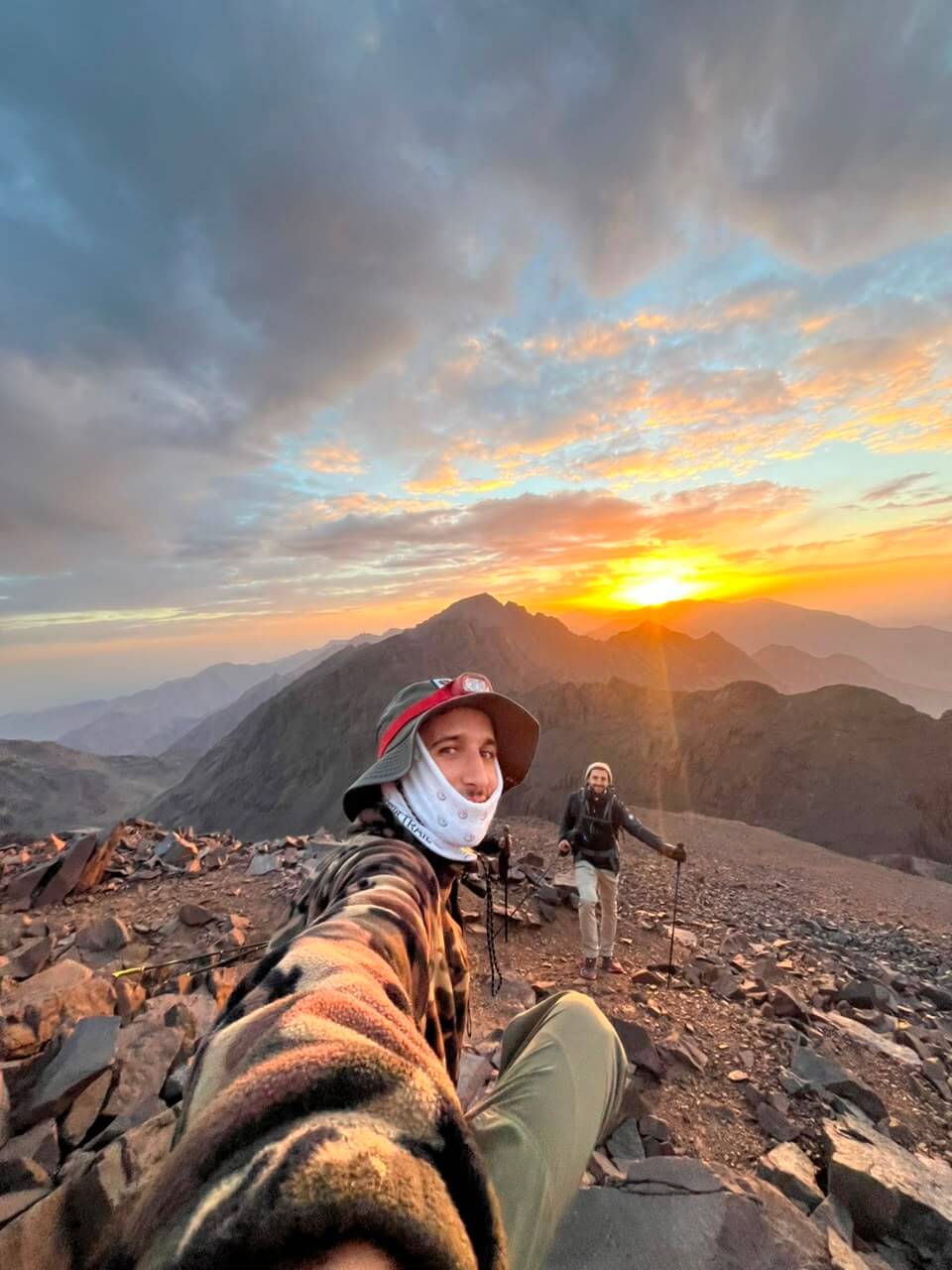 Mountain guide Radouane and clients watching sunrise in the High Atlas Mountains near Ouanoukrim