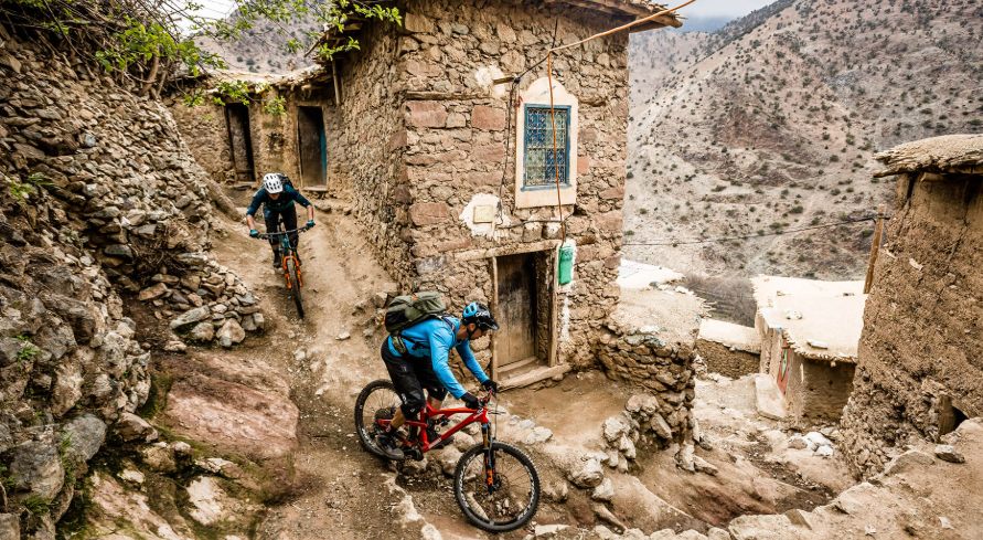 Mountain biker riding through a Berber village in Morocco
