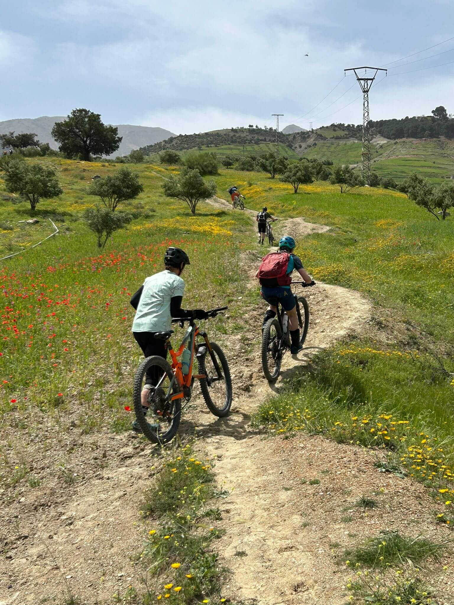 Mountain bikers riding a dirt trail through the Atlas Mountains of Morocco