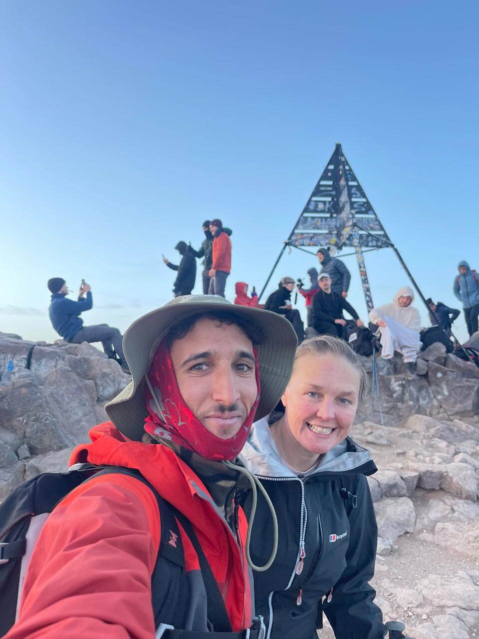 Trekker celebrating reaching the summit of Mount Toubkal at 4,167 metres in Morocco